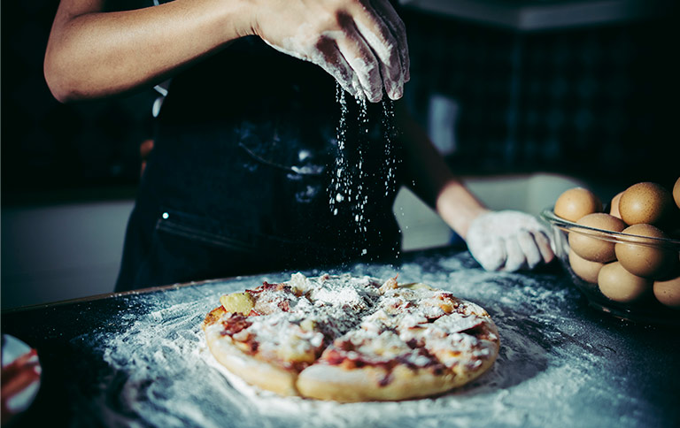 Espolvoreando harina en pizza